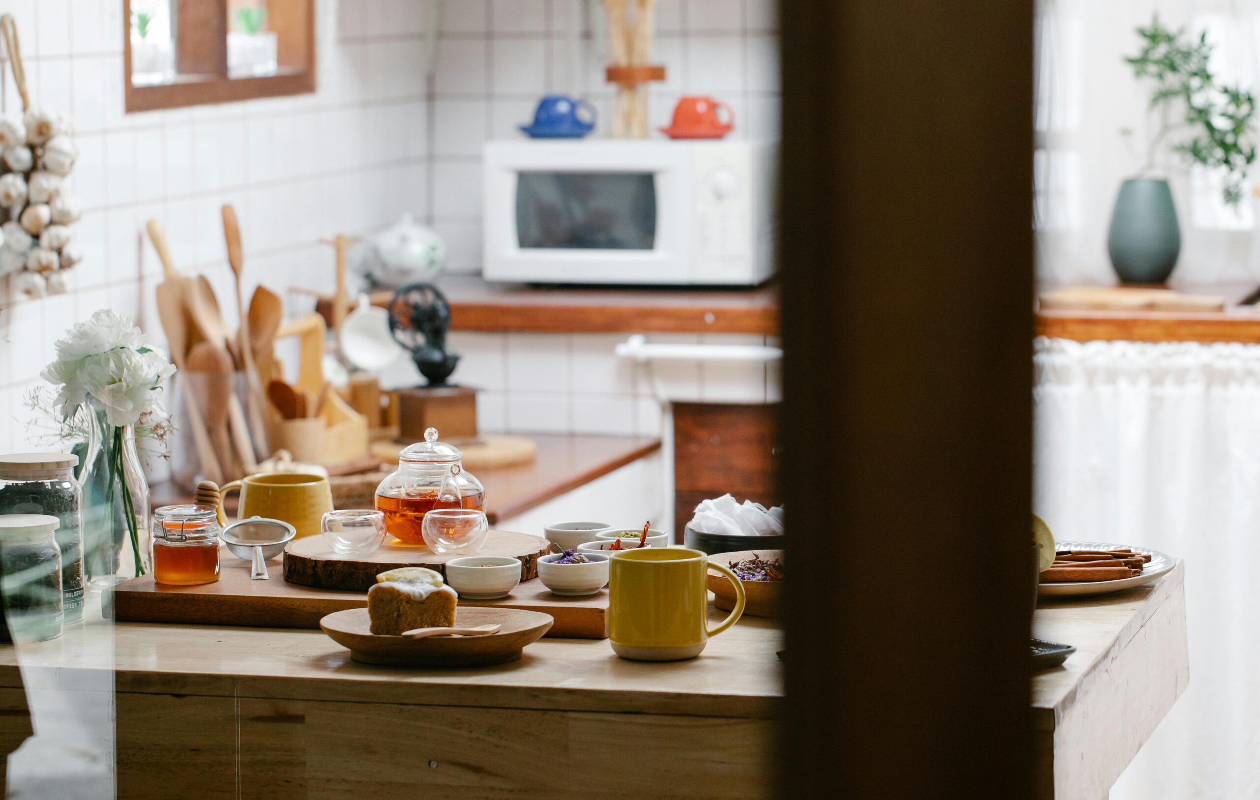 A warm kitchen scene with a teapot, mugs, and breakfast items on the counter, perfect for lifestyle content.